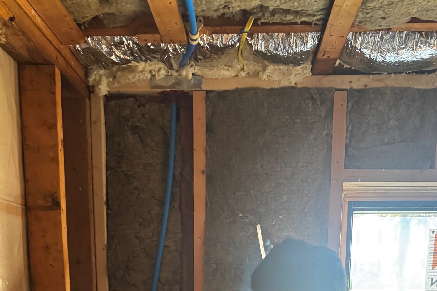 Insulated walls and ceiling around a new window during an air sealing and insulation job