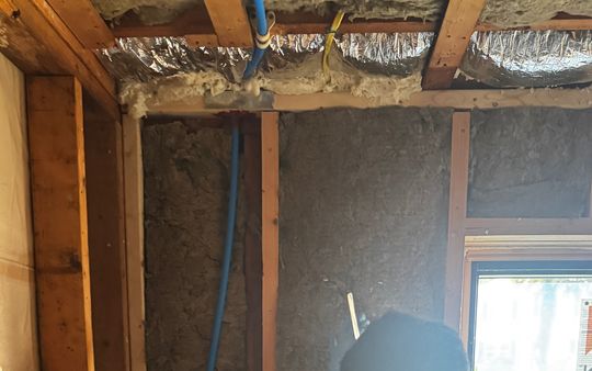 Insulated walls and ceiling around a new window during an air sealing and insulation job