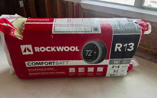 Package of R-13 mineral wool insulation batts for 2x4 walls on a renovation floor