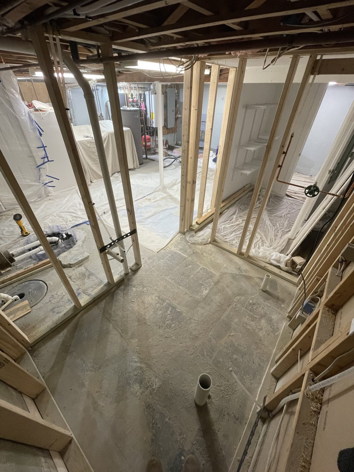 Open basement framing with plumbing lines before insulation