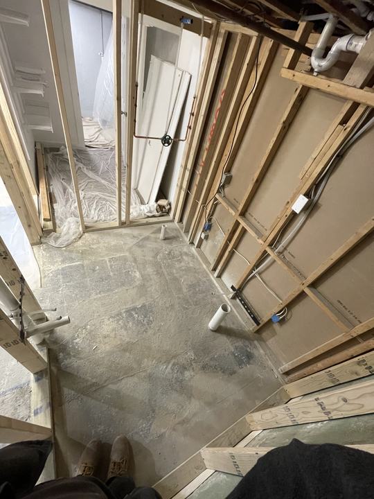 Open framing with new plumbing lines during a basement renovation