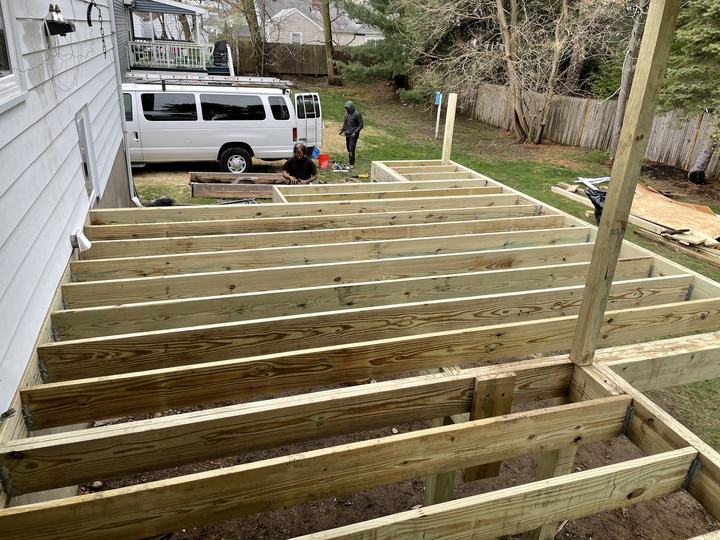 Construction site with new framing and a work van in the driveway