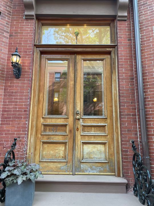 Restored historic wooden double front door in a brick entry