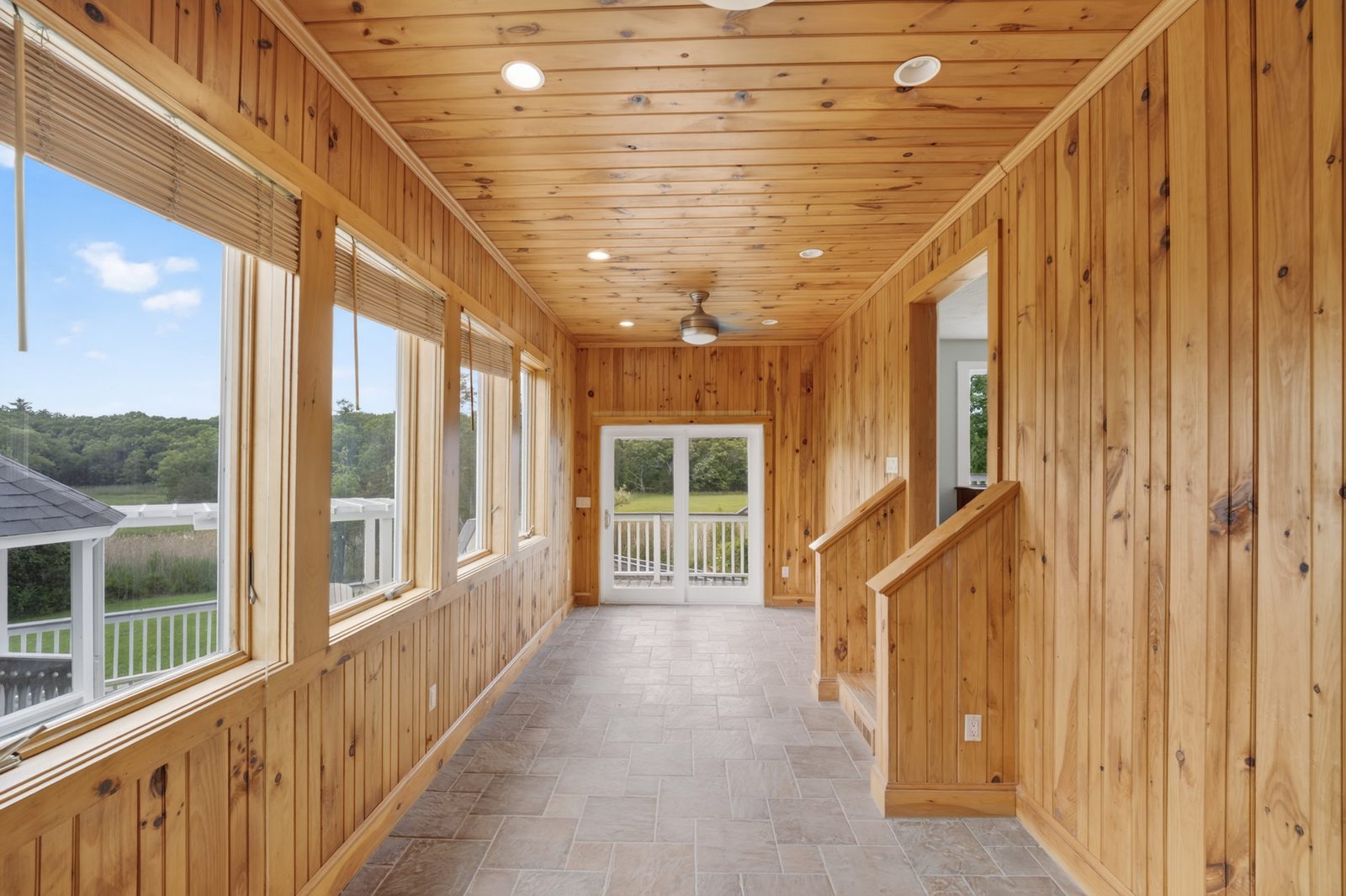 Renovated sunroom with wood-paneled walls and ceiling