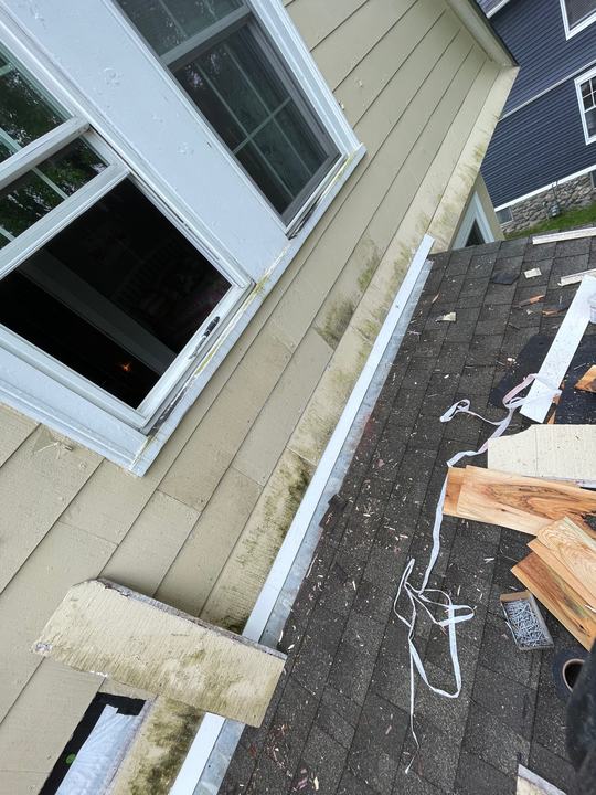 Exterior siding and window trim repair on an older house