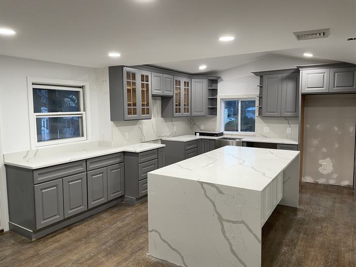 Renovated kitchen with gray shaker cabinets and a quartz island